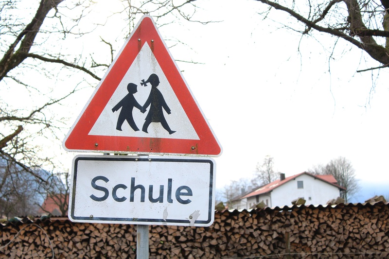 2K, europe, warning sign, nature, shape, road sign, day, human representation, information, bare tree, representation, no people, school, travel, triangle shape