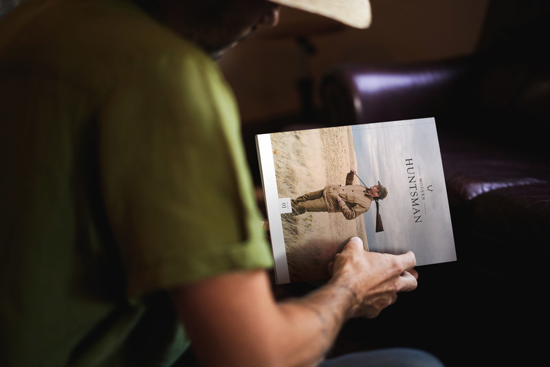 sitting, sofa, holding, picture, men, indoors, text, human body part, economy, finance, 5K, human hand, photo, midsection, one person, cowboy, hunting