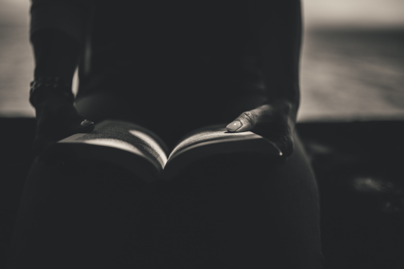 human leg, lifestyles, indoors, human body part, one person, sitting, person, learning, studying, reading, hand, read, midsection, front view, open, focus on foreground
