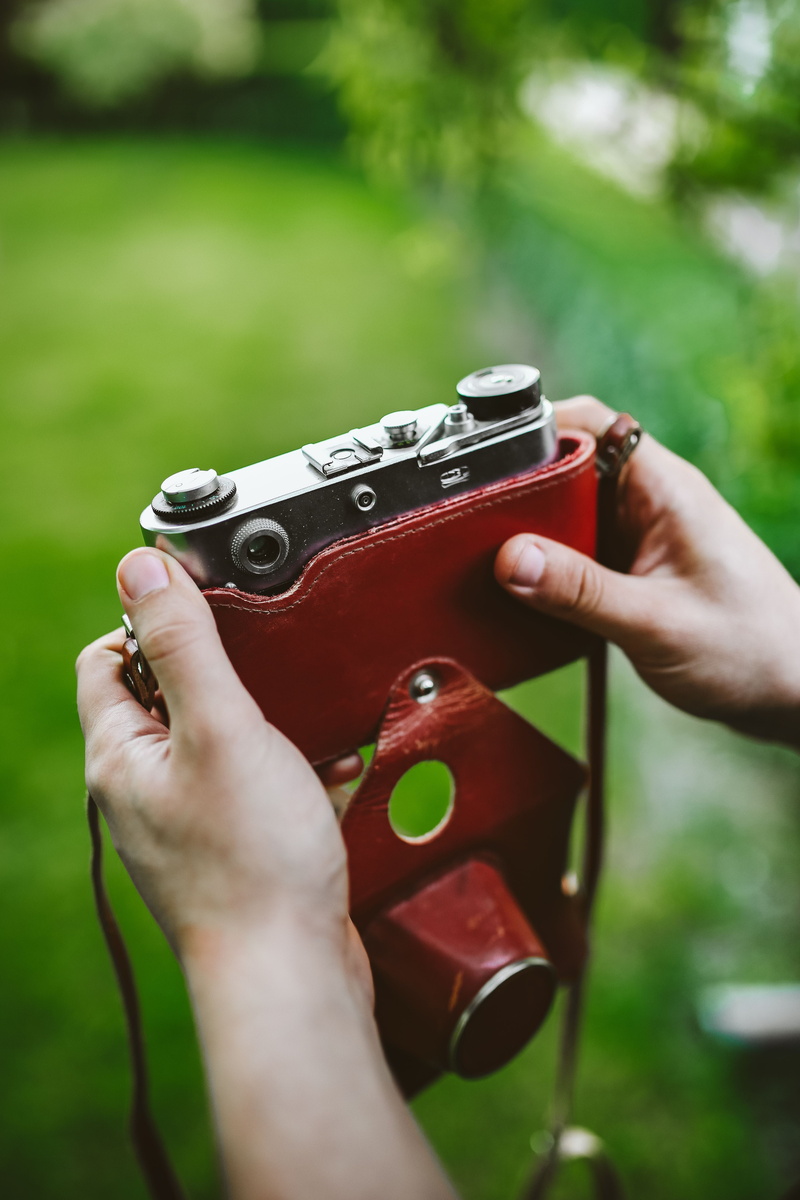 grass, real people, music, close-up, finger, one Person, day, leisure activity, outdoors, selective focus, musical instrument, human Hand, camera - Photographic Equipment