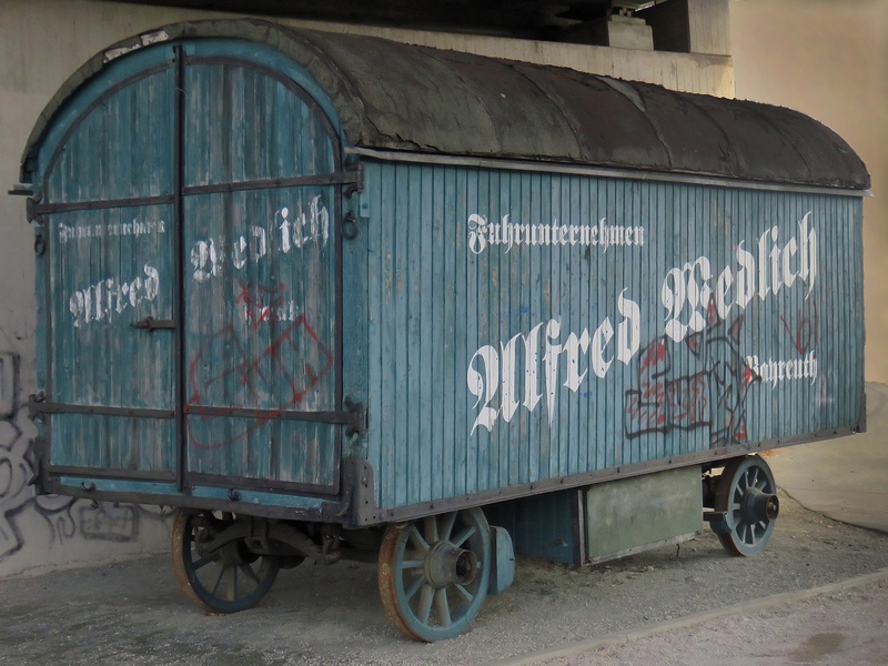 truck, no people, shipping, 2K, transportation, communication, city, old, built structure, western script, text, outdoors, number, metal, wheel, road