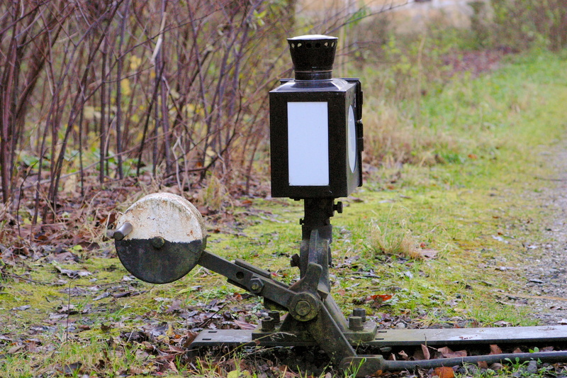 metal, day, technology, grass, outdoors, rail traffic, platform, nature, focus on foreground, rail transportation, no people, close-up, electric lamp, plant