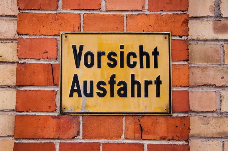 western script, shield, wall, street sign, signal, road, warnschild, sign, architecture, red, building exterior, yellow, warning signs, information, built structure