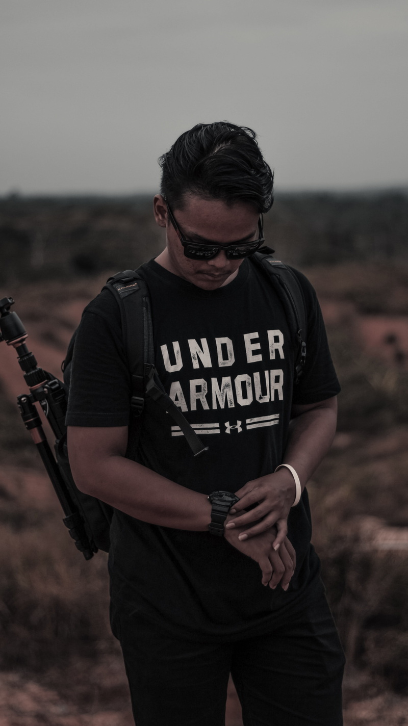 standing, young adult, black, holding, shirt, focus on foreground, tripod, person, casual clothing, nature, armour, man, communication, one person, leisure activity