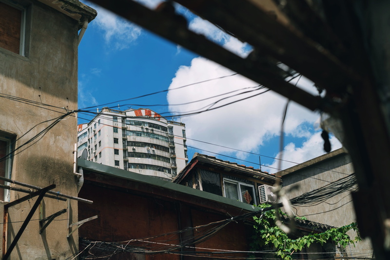 low angle view, tree, sunlight, architecture, cable, day, street, built structure, window, sky, residential district, city, building, no people, shanghai