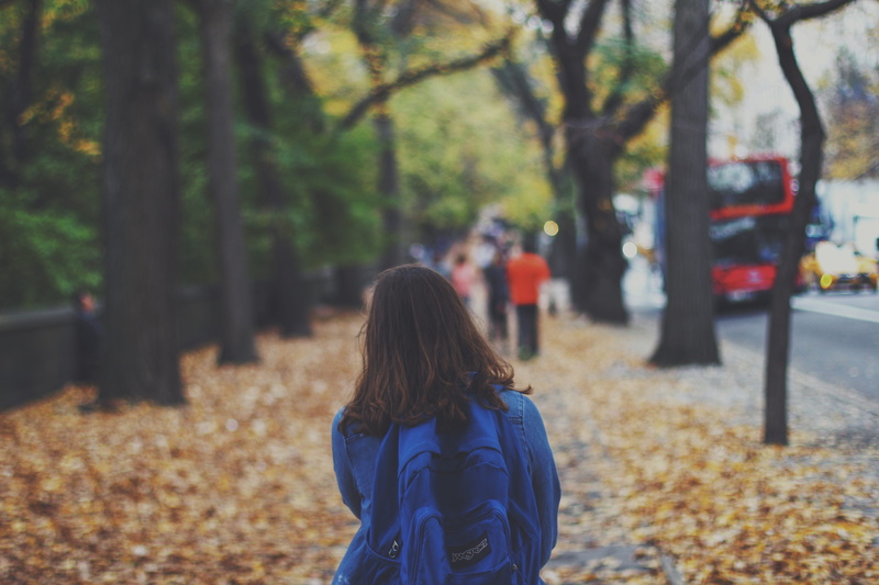 leaves, plant, warm clothing, standing, backpack, 5K, person, land, child, blue, bus, day, covered, dried, lifestyles, tree, hair, woman, sidewalk, clothing