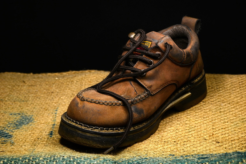 brown, flooring, surface, worn, carpet - decor, pair, work, lace - fastener, mat, boots, dirty, black, boot, no people, shoe, single object, studio shot