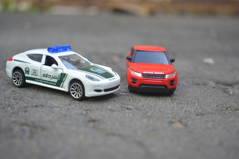 high angle view, two objects, selective focus, street, motor vehicle, close-up, city, day, miniature, diecast, toys, mode of transportation, road, transportation