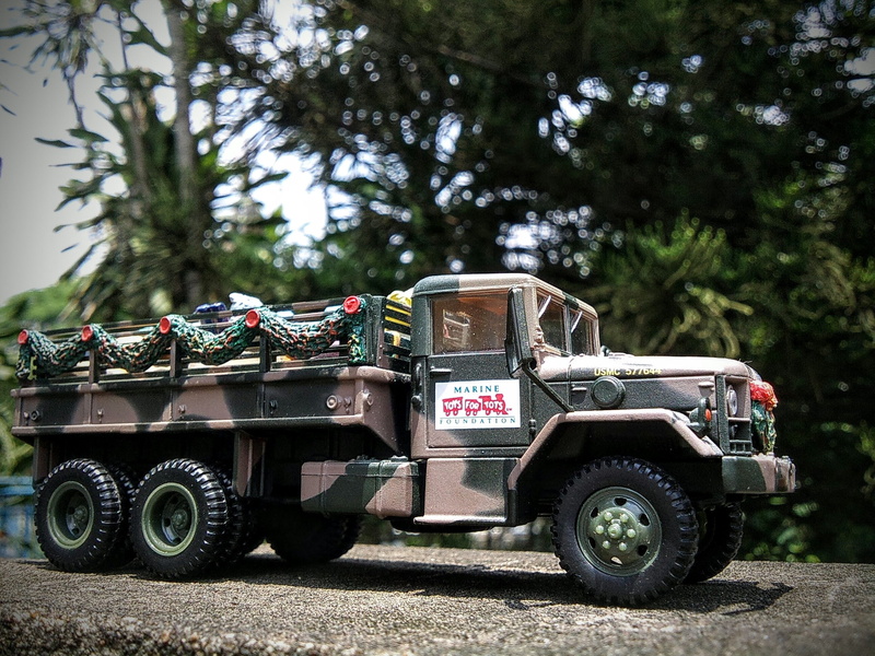 diecast, 2K, tree, field, sunlight, truck, wheel, land vehicle, transportation, group of people, day, focus on foreground, mode of transportation, nature