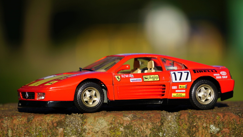 toy car, day, miniature, focus on foreground, car, model car, number, selective focus, mode of transportation, black, competition, land vehicle, no people