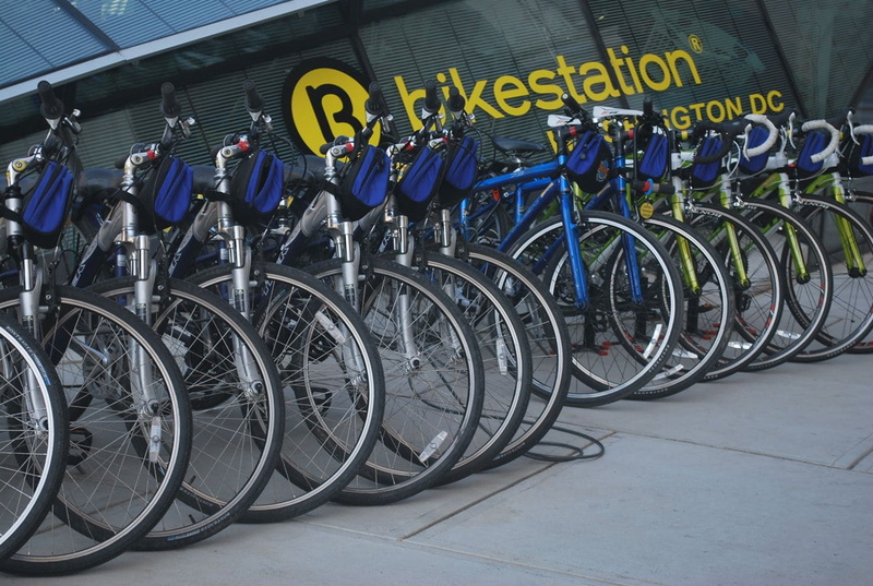 architecture, business, stationary, land vehicle, wall - building feature, cycle, bicycle rack, side by side, transportation, large group of objects, communication
