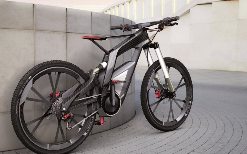Audi bike, wheels, outdoors, day, parking, wheel, mode of transportation, bicycle, bicycle rack, footpath, no people, metal, sidewalk, wall - building feature