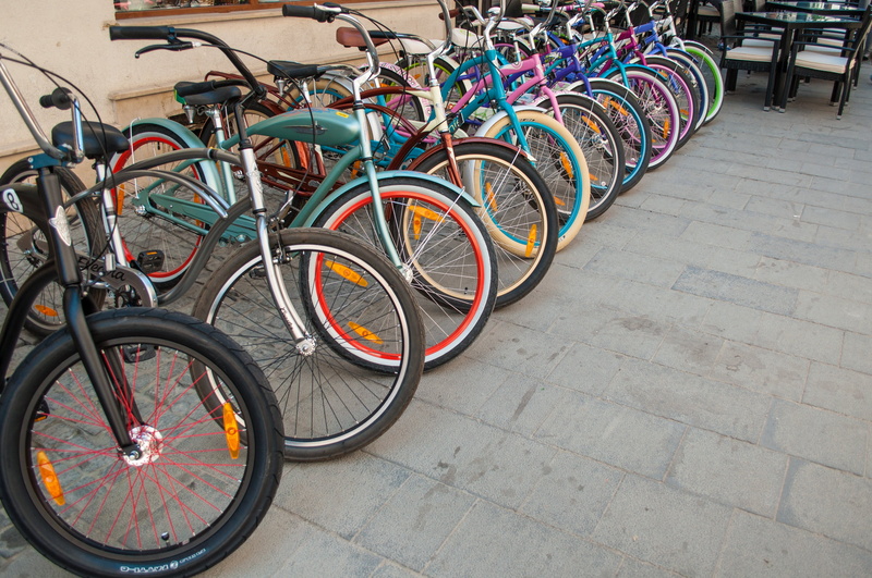in a row, multi colored, transportation, mode of transportation, day, bicycle rack, footpath, stationary, paving stone, high angle view, bicycle, travel