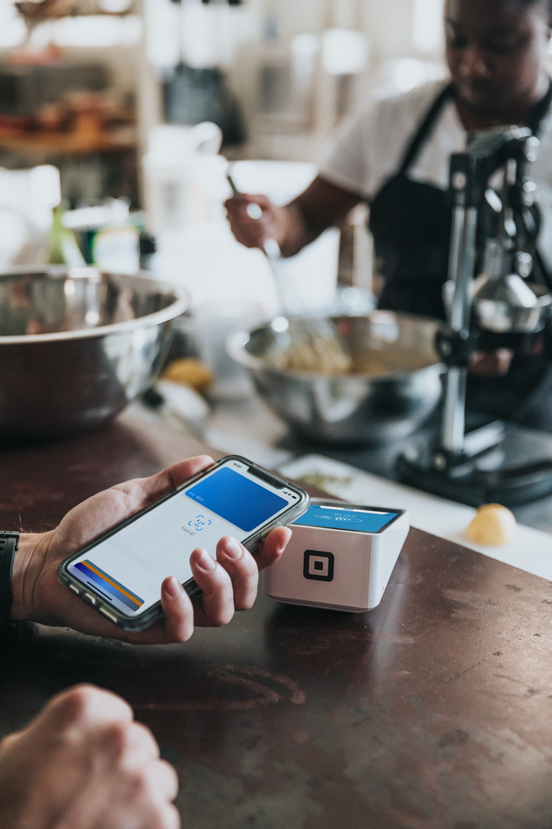 one person, human body part, cell phone, wireless technology, finger, monitor, 5K, square, apple pay, indoors, credit card, table, business, pos, lifestyles