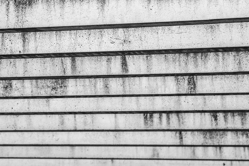 day, outdoors, sunlight, beams, no people, wall, urban, weathered, plank, dirt, built structure, stone, pattern, cement, architecture, black and white