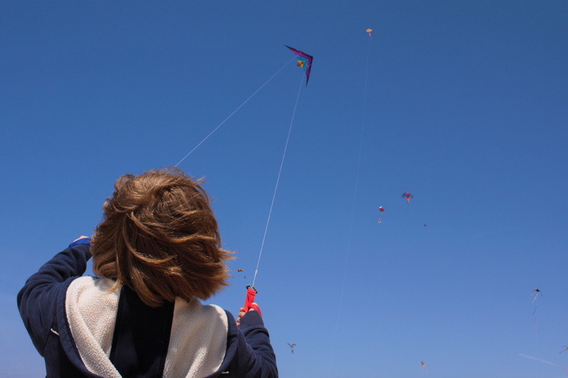 kite - toy, leisure activity, real people, rear view, hair, sky, portrait, women, day, child, flying, casual clothing, wind, adult, nature, warm clothing