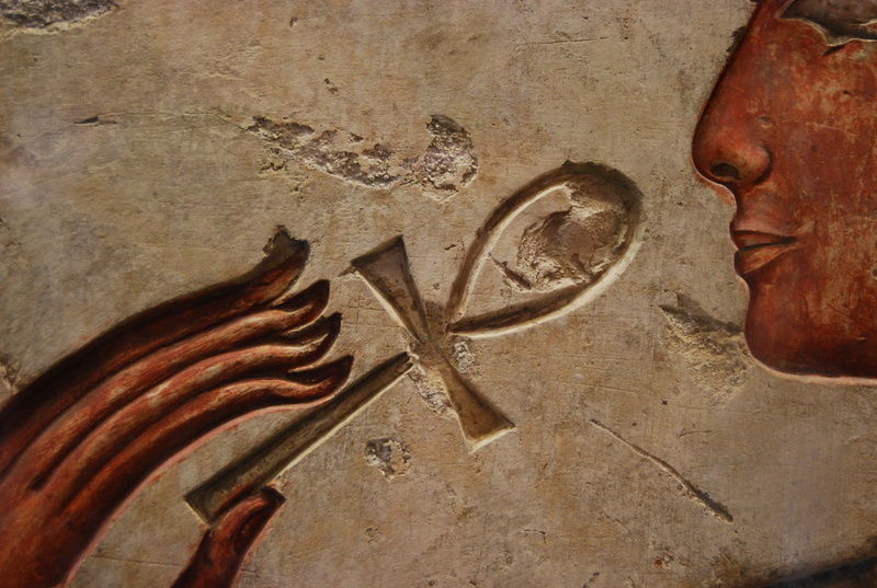 high angle view, sculpture, wall, close-up, table, old, human representation, carving - craft product, wall - building feature, ankh, indoors, metal, no people