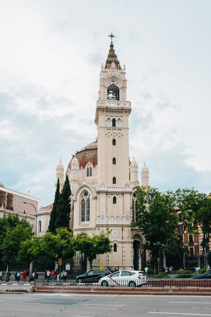 city, sky, nature, tall - high, catholic, spire, tree, mode of transportation, calle de alcalá, incidental people, madrid, building, spain, cloud - sky