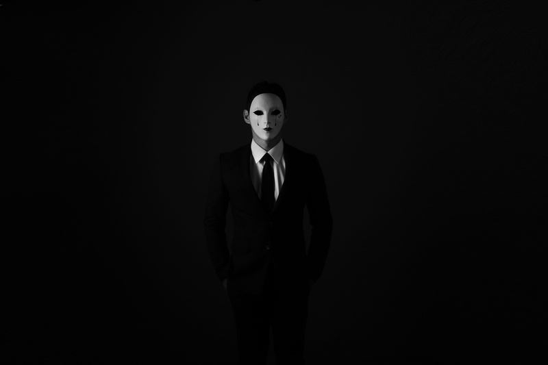 studio shot, black background, looking at camera, copy space, mask, well-dressed, adult, business, v for vendetta, anonymous, contemplation, standing, 5K