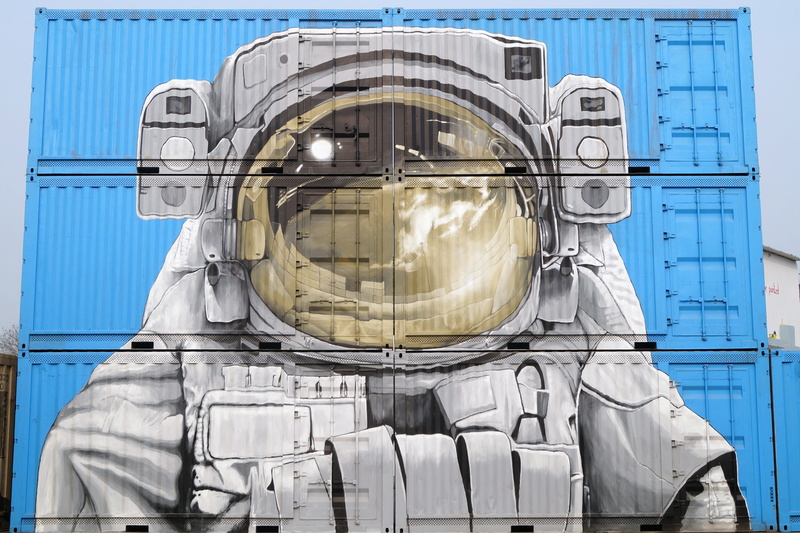 art, headwear, blue, built structure, architecture, building exterior, clothing, transparent, semi-trailers, helmet, graffiti, trailers, day, artistic