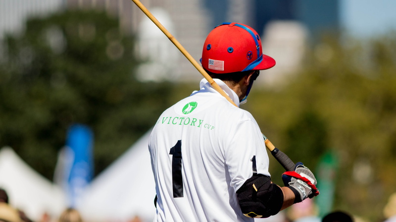 rear view, human limb, cricket, bat, playing, carrying, polo, day, men, stick, man, waist up, focus on foreground, wearing, headwear, safety, one person