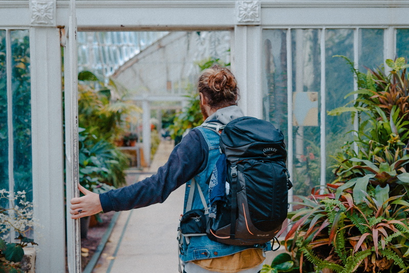 denim, outdoors, near, backpack, green, hike, finger tattoo, rear view, going, real people, one person, flower, door, architecture, glasshouse, lifestyles