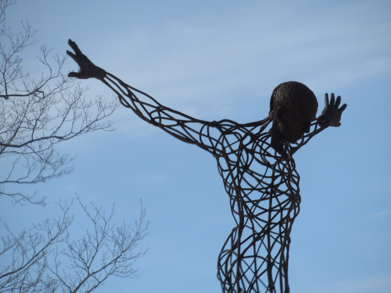 ironwork, sky, man, bare tree, one person, spirituality, sculpture, low angle view, canada, branches, tree, belief, silhouette, religion, rear view, lifestyles