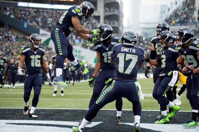 group of people, clothing, american football field, outdoors, seattle seahawks, american football - sport, american football - ball, uniform, helmet, people
