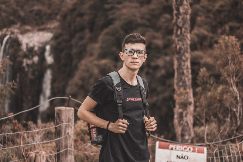 young, forest, tree, leisure activity, text, short sleeve, real people, guy, backpack, hike, outdoors, explore, young men, focus on foreground, smiling