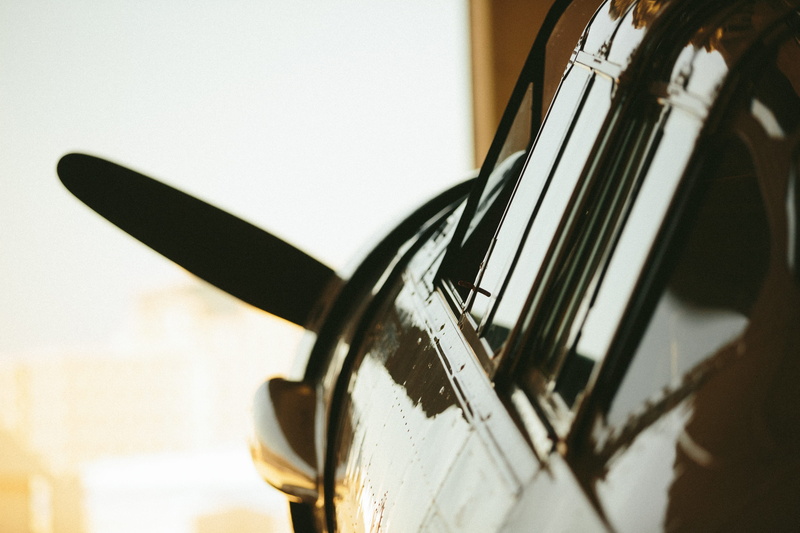 indoors, film reel, plane window, warbird, metal, domestic room, golden light, untitled, still life, history, technology, focus on foreground, close-up