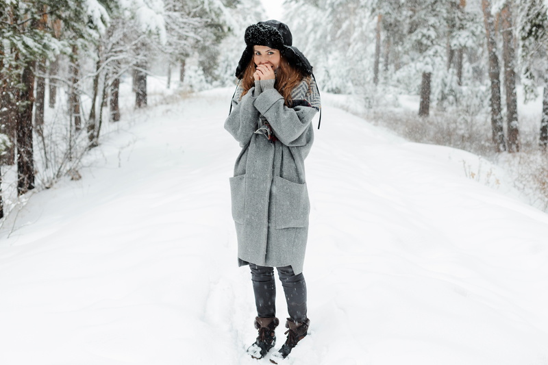 one person, trees, stroll, woman, cap, outdoors, lifestyles, extreme weather, cold temperature, winter, snow, tree, adult, coat, girl, young women, emotions