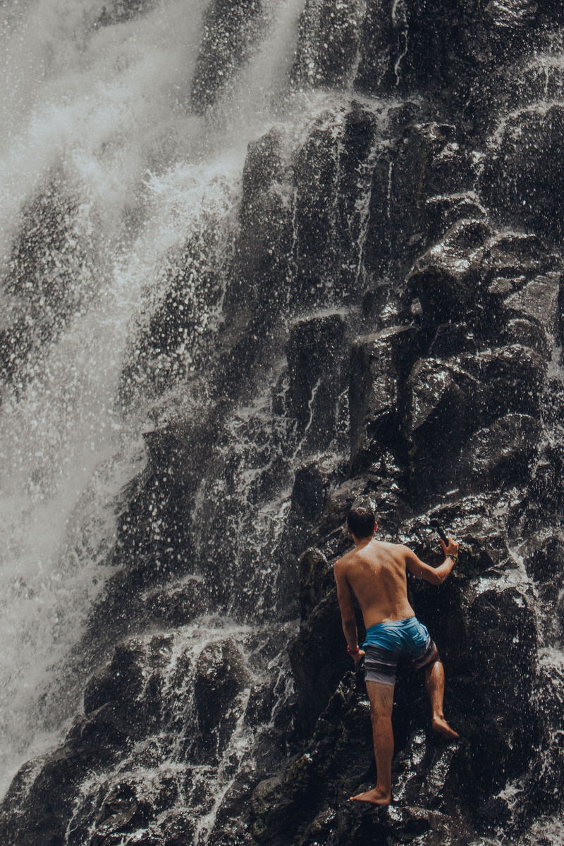 one person, outdoors, federated states of micronesia, sea, rear view, rock - object, solid, waterfall, water, kepirohi waterfall, splashing, rock, day