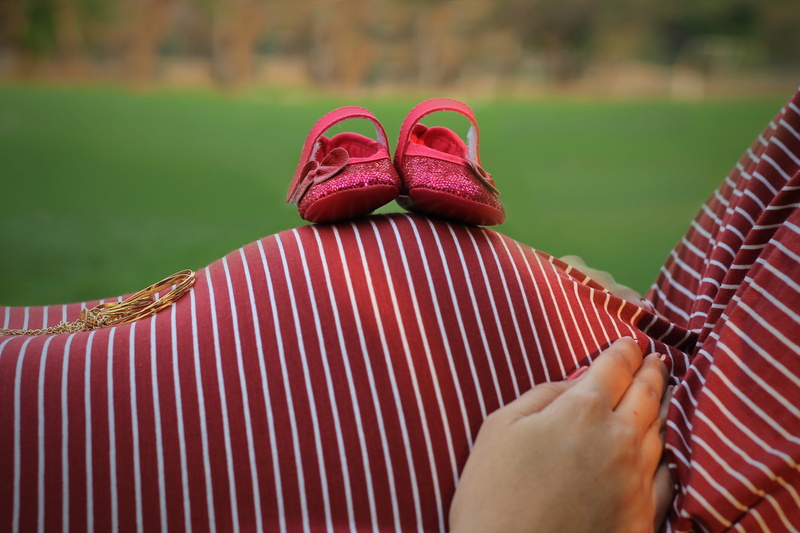clothing, slippers, day, grass, adult, field, mother, human hand, one person, 4K, lifestyles, close-up, maternity, outdoors, pregnancy, family, body part