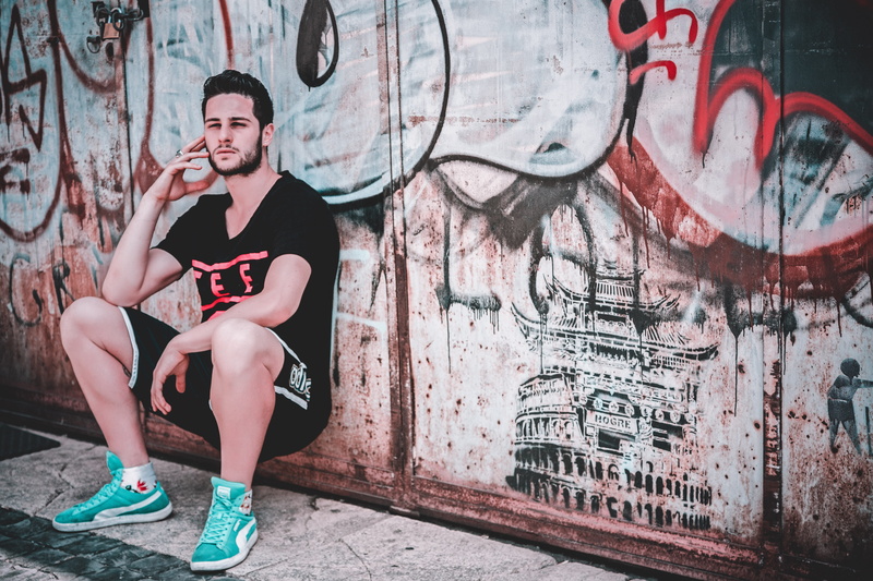 art and craft, jogger, wall - building feature, clothing, shorts, outdoors, young adult, graffiti, messy, architecture, vandalism, leisure activity, portrait