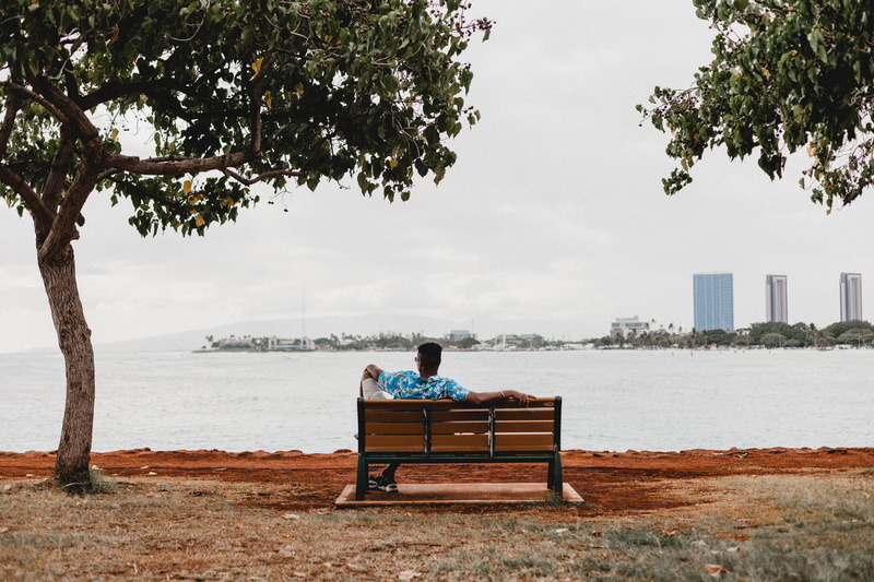 plant, men, calm, person, sky, outdoors, clothing, tree, day, facing, man, bench, park bench, looking at view, honolulu, built structure, seat, sitting