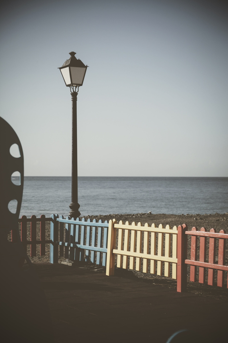 lighting equipment, built structure, fence, plaque, railing, steeple, lute, tower, picket, sky, lamp, beauty in nature, horizon, building, tranquil scene