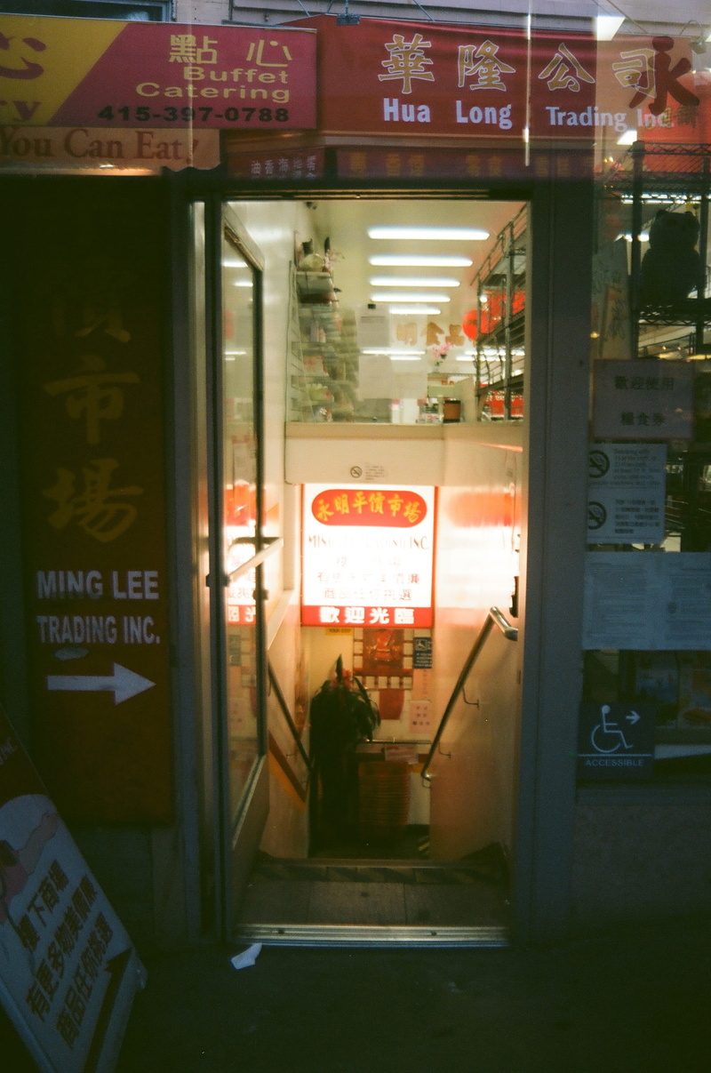 window, bus stop, arcade game machine, person, candy, flooring, banister, text, public transportation, glass - material, script, door, no people, indoors
