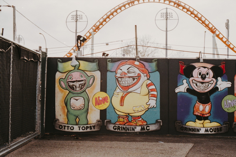 toy, communication, mural, representation, wall, outdoors, daytime, advertisement, painting, three, amusement park, billboard, racket, art, inflatable