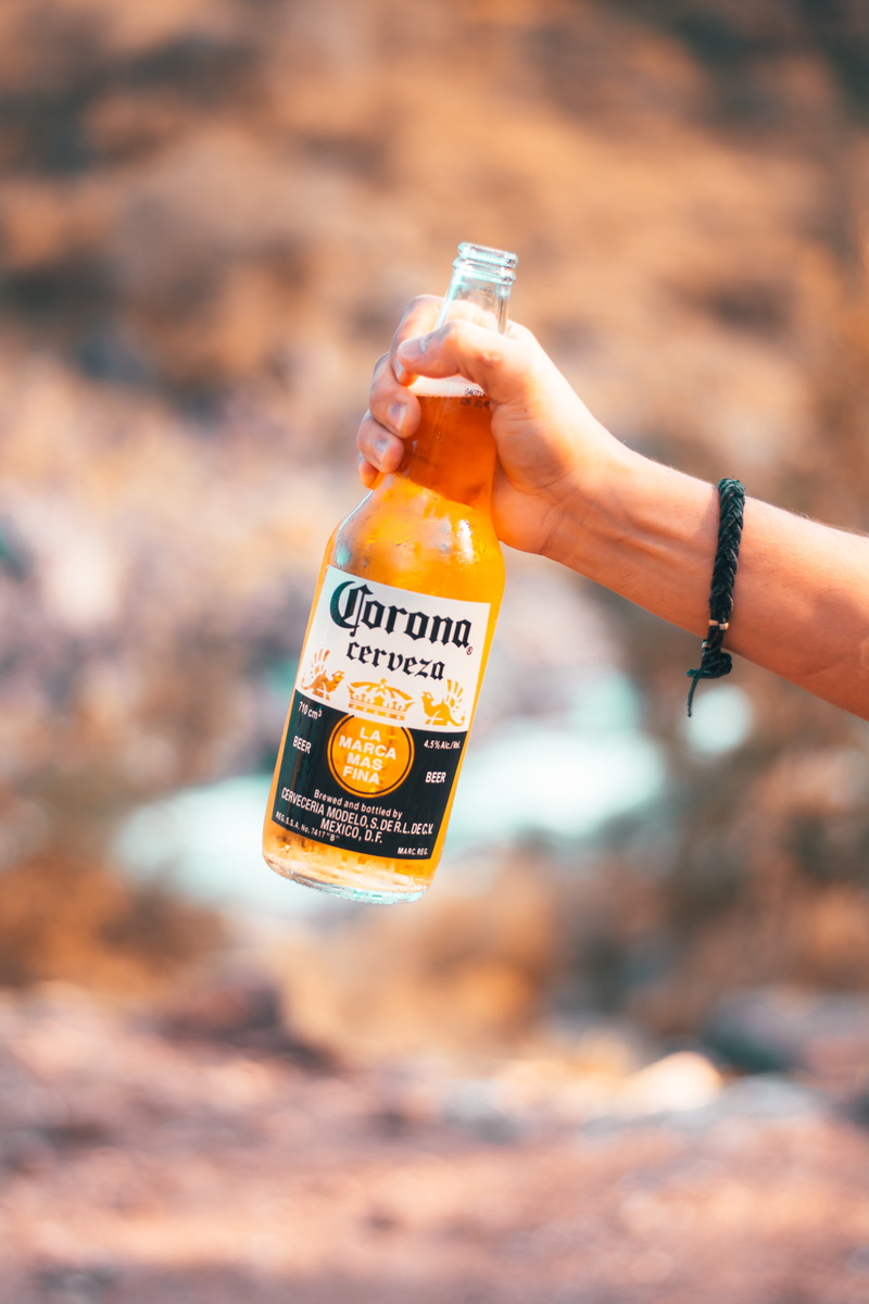 outdoors, focus on foreground, human hand, bottle, food and drink, unrecognizable person, finger, cerveza, 5K, day, refreshment, drink, real people, human body part