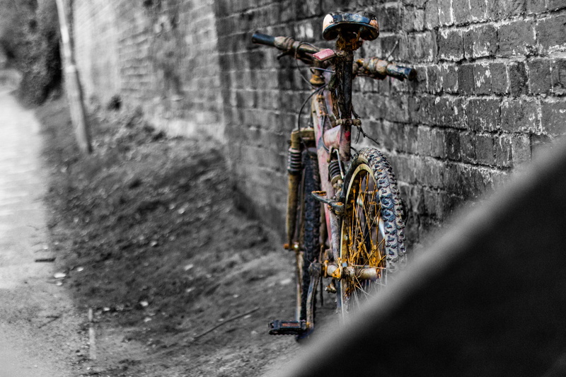 bike, close-up, wall - building feature, city, transportation, stone wall, selective focus, focus on background, wheel, water, vintage, rain, land vehicle