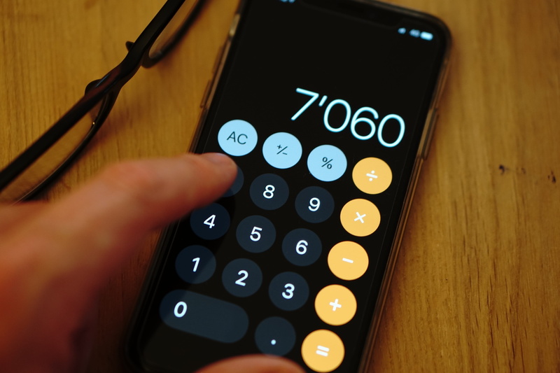 leisure activity, table, wireless technology, high angle view, number, one person, calculation, human body part, connection, count, holding, mathematics