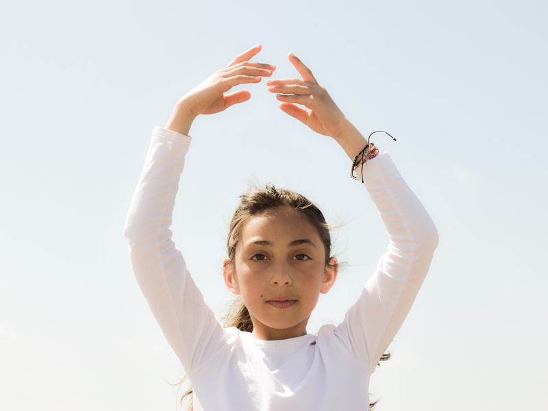 child, 5K, front view, light, children only, one girl only, hairstyle, girls, childhood, wellness, balance, sky, peace, hand, headshot, gesturing, looking at camera