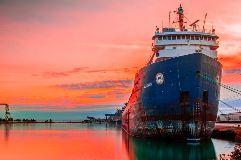 sailboat, shipping, protection, sea, outdoors, tower, transportation, architecture, water, oil, mode of transportation, orange color, nature, cloud - sky
