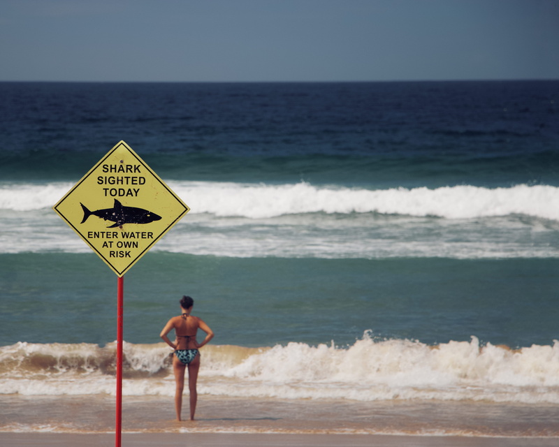 water, beauty in nature, outdoors, beach, sign, communication, standing, wave, one person, sky, beside, text, nature, sea, horizon over water, day, shirtless