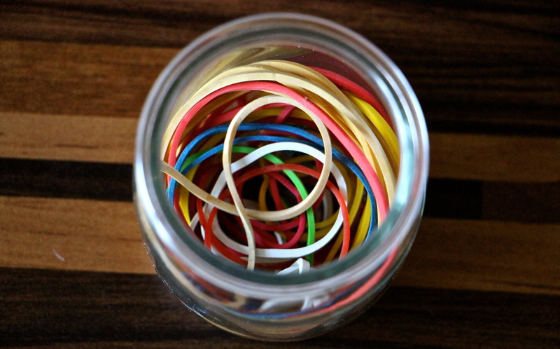 kitchen utensils, multi colored, indoors, household equipment, 5K, focus on foreground, glass, large group of objects, colorful, tools, rubber bands, directly above