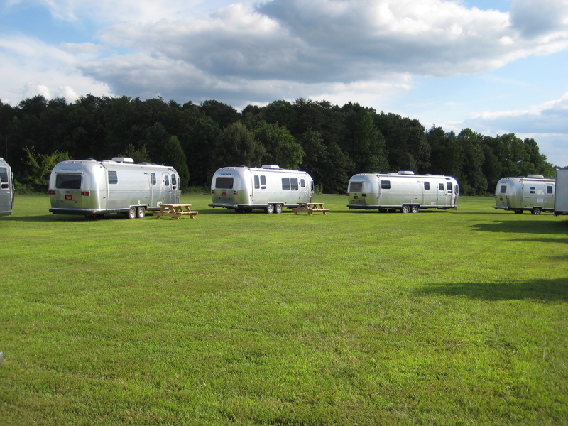 land Vehicle, beauty in nature, field, campsite, no people, motor vehicle, trailer Home, green, mode of Transport, grass, tree, landscape, camping, daytime