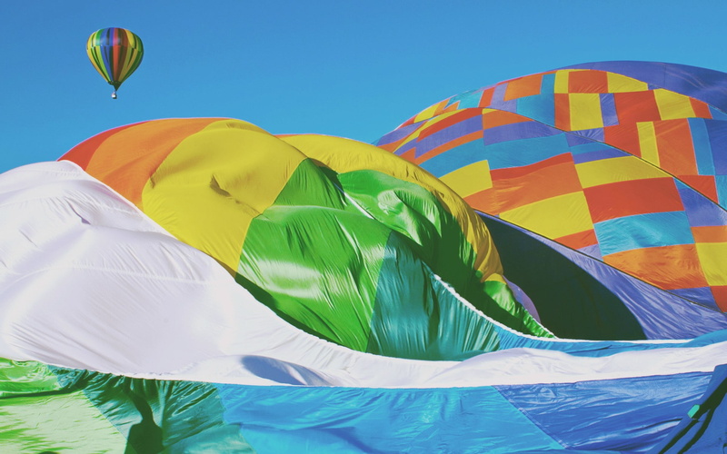 multi colored, environment, clear sky, sky, balloon, hot air balloon, adventure, mid-air, low angle view, freedom, celebration, day, ballooning festival