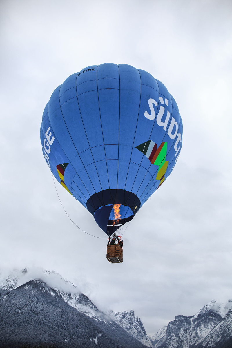 aircraft, ball, leisure activity, white, mid-air, freedom, sport, snow, person, leisure activities, balloon, air vehicle, snowcapped mountain, beauty in nature