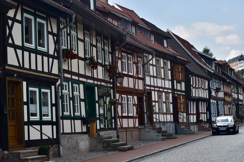 transportation, half-timbered houses, cloud - sky, location, outdoors, row house, architecture, land vehicle, sky, city, built structure, motor vehicle