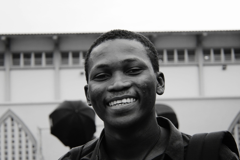 finger, young men, apparel, built structure, one person, real people, monochrome, laughing, fiesta, focus on foreground, emotion, teeth, lifestyles, architecture